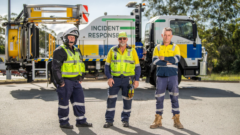 Members of the Brisbane Motorway Services team standing in front of an incident recovery truck